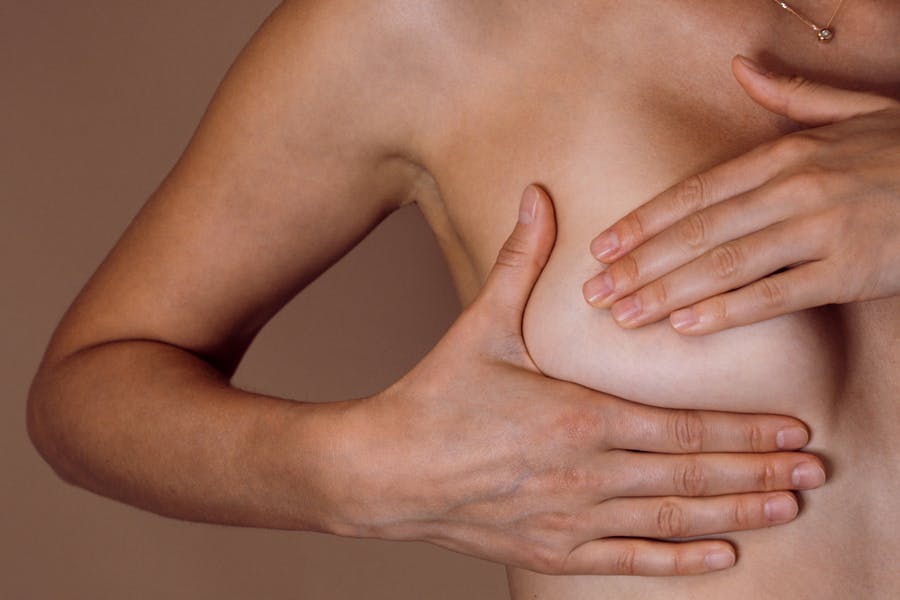 Nainen etsii tunnustelemalla muutoksia rinnastaan