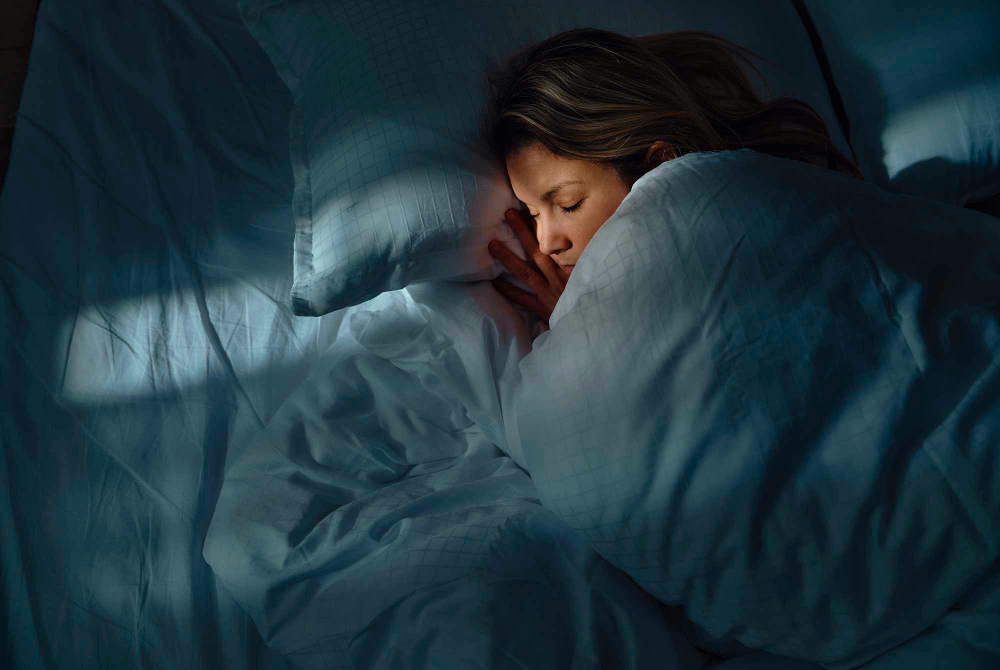 Kvinna sover djupt i sin säng