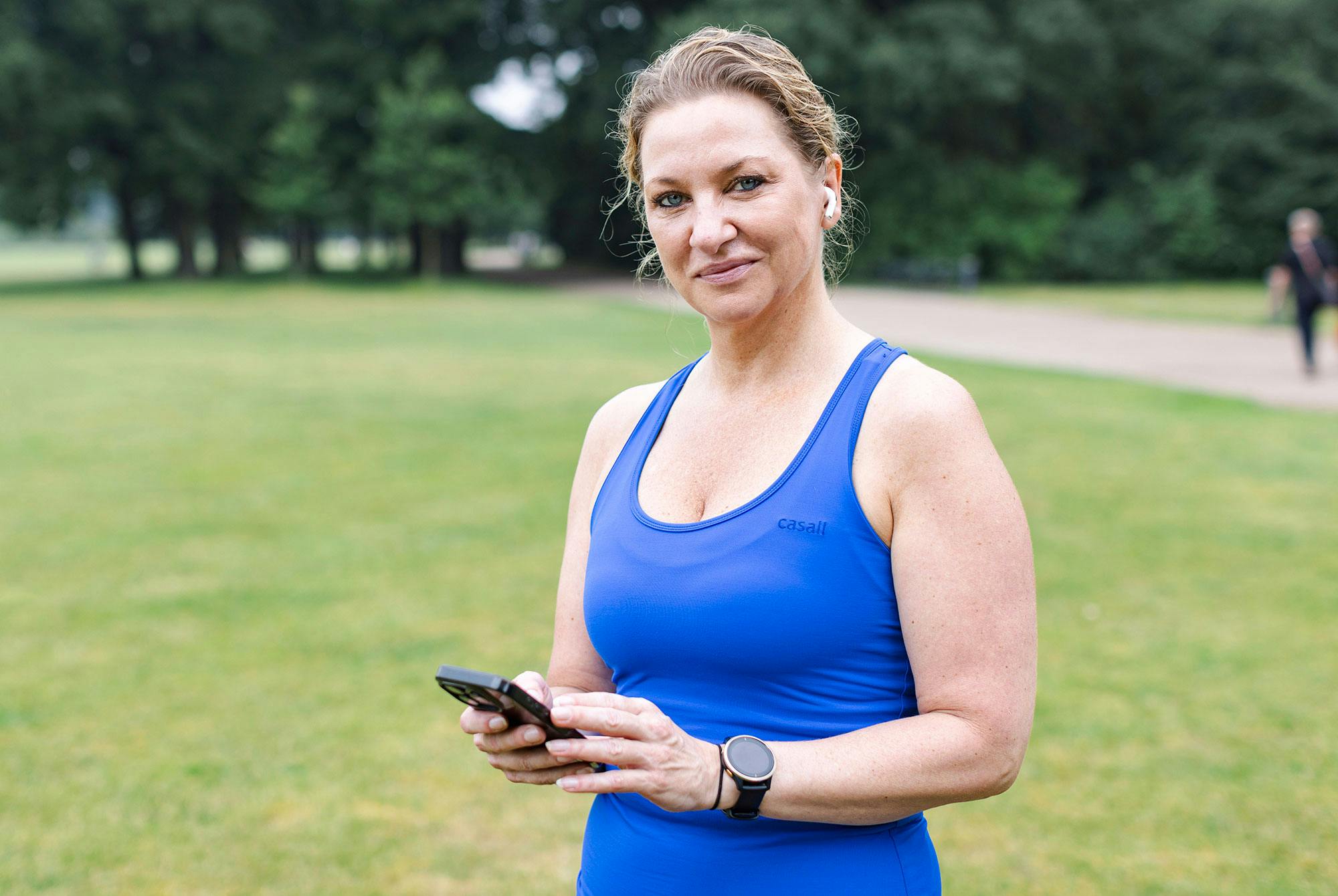Sidse står med sin telefon i handen. Hon har följt löparprogrammet för nybörjare.