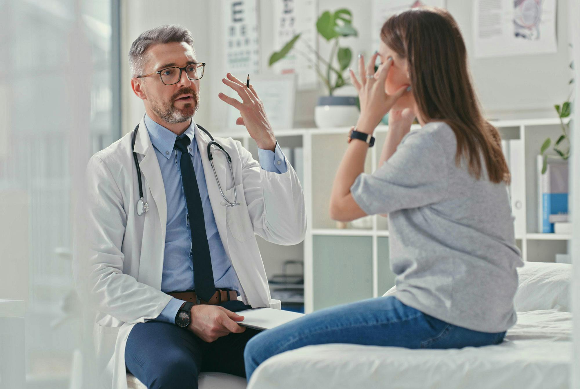 En kvindelig patient forklarer, hvordan hendes smerter opleves, til sin læge.