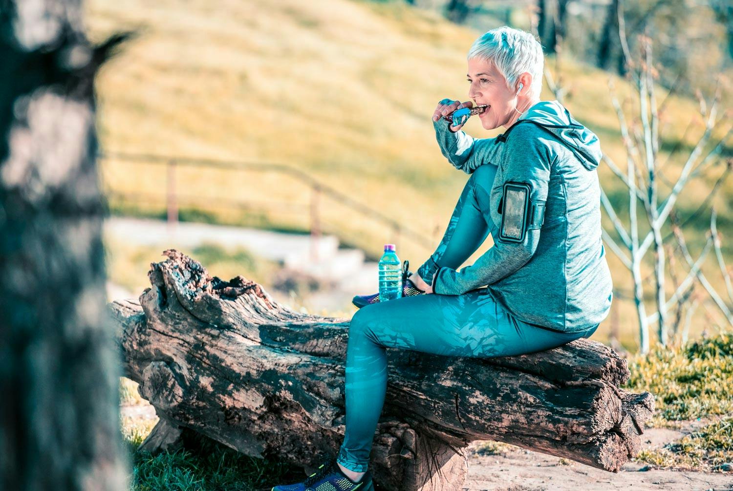 Kvinne spiser snacks etter utendørstrening – trening øker kaloribehovet, så vedlikeholdsinntaket stiger. Hvor mye kan du regne ut med I FORMs kalorikalkulator.