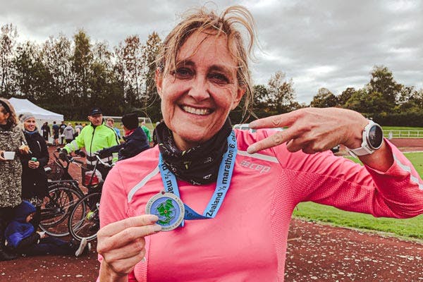 Glad löpare visar upp sin medalj