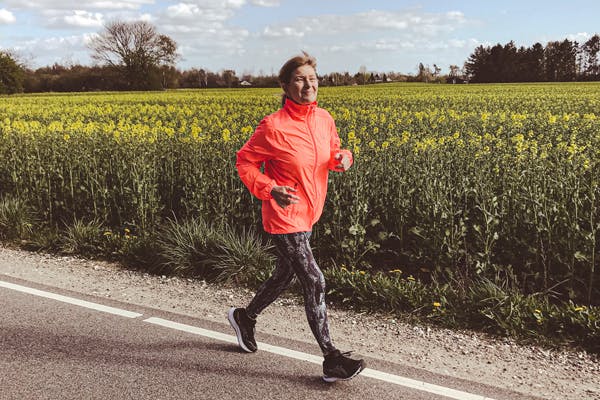 Aikuinen nainen uoksulenkillä pellon laidassa maantiellä