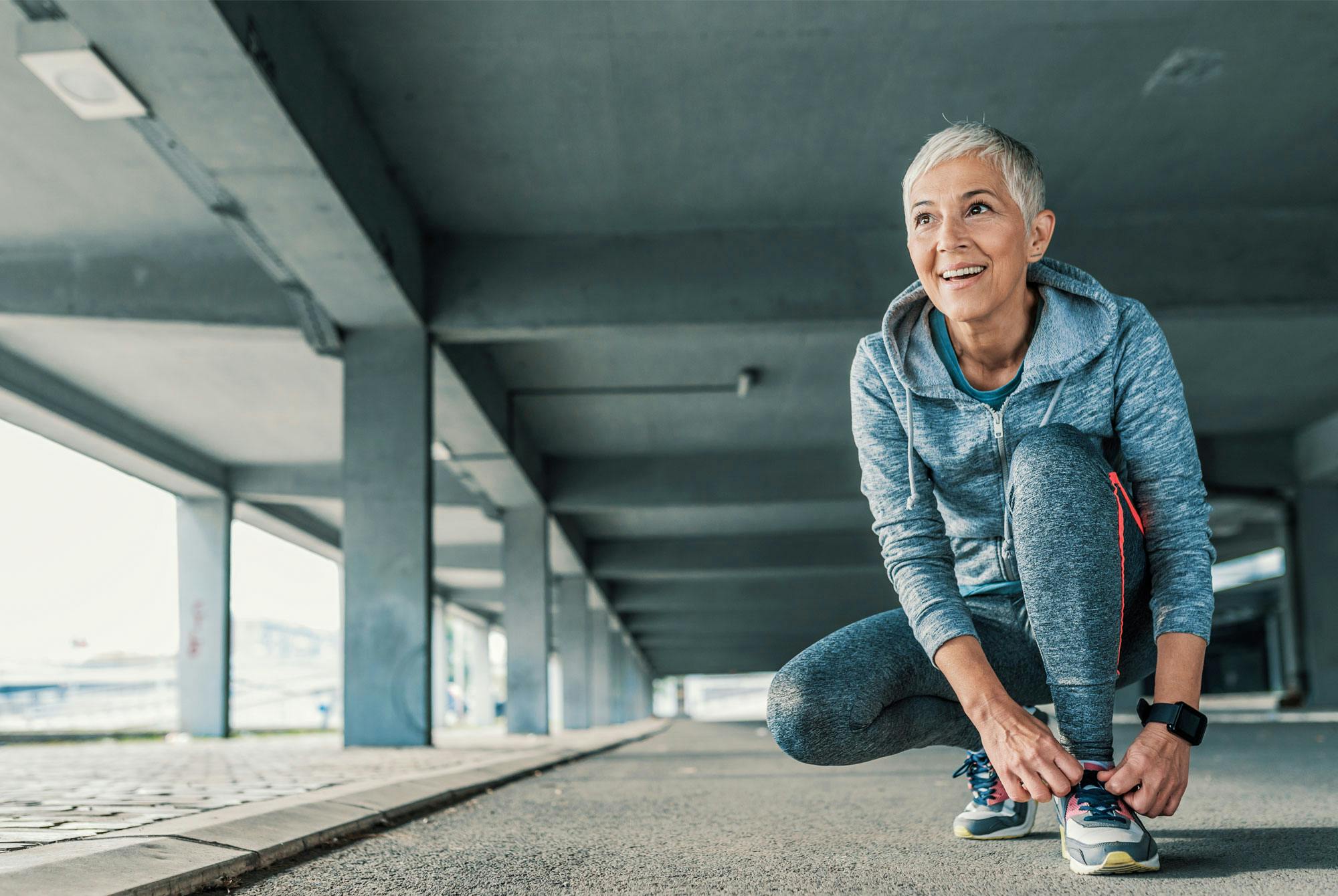 Kvinna knyter på sig skorna under en löptur