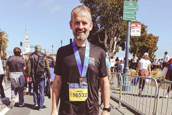 Laiha, parrakas mies juoksutapahtuman maalissa mitali kaulassa