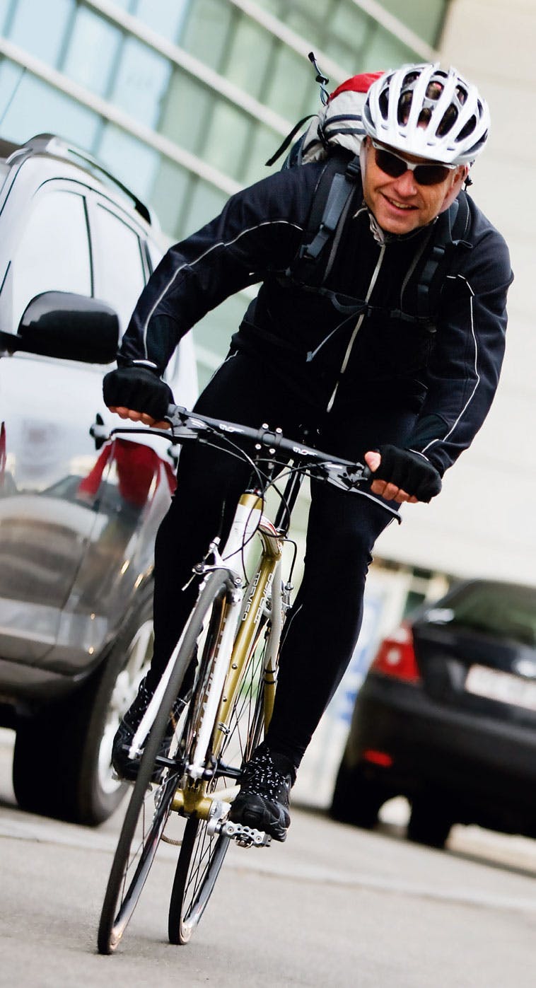Glad manlig cyklist med vit cykelhjälm