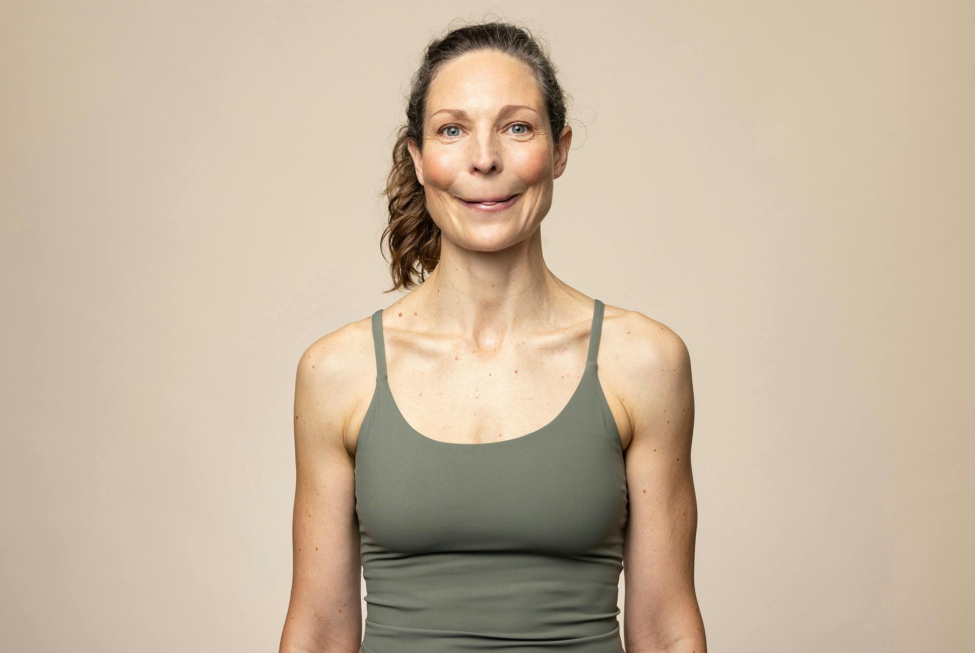 Kvinde laver øvelsen "Mona Lisa-smilet" – ansigtsyoga