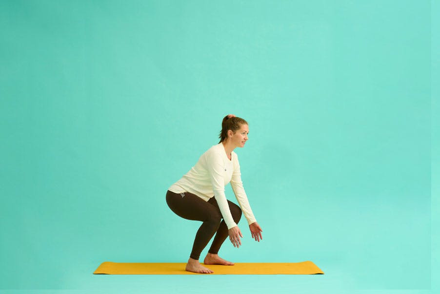 Kvinde laver squat med armløft