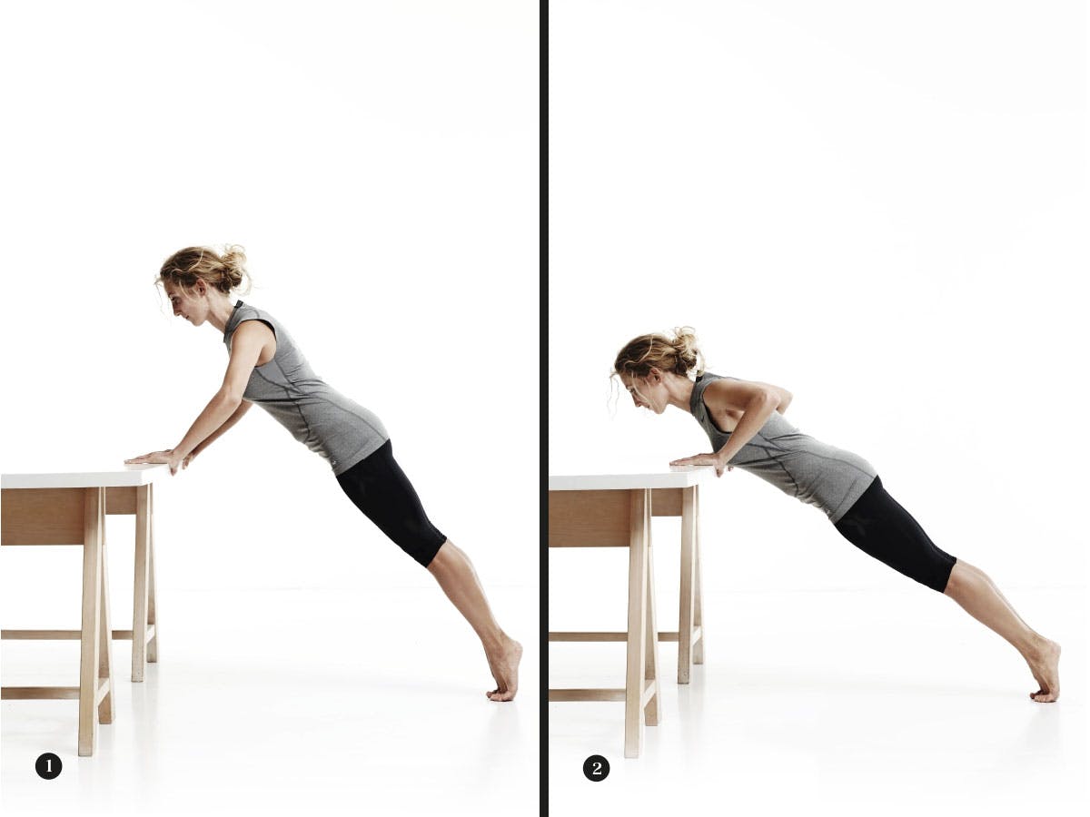 Kvinna gör armhävning mot bord