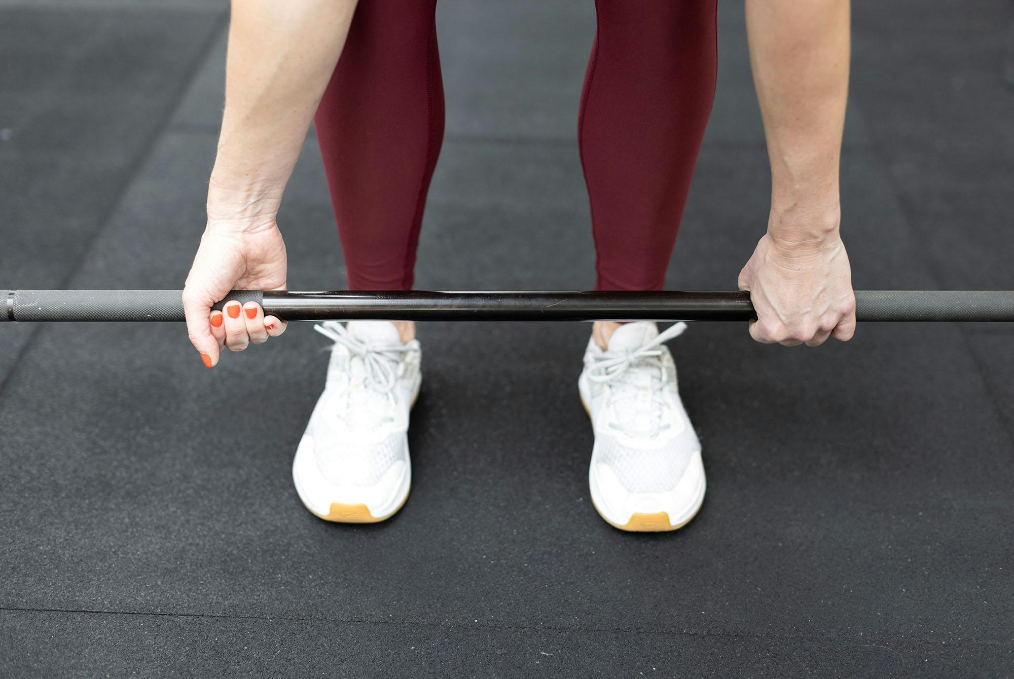 Krydsgreb til dødløft holder vægtstangen på plads– den ene håndflade vender mod kroppen og den anden vender væk.