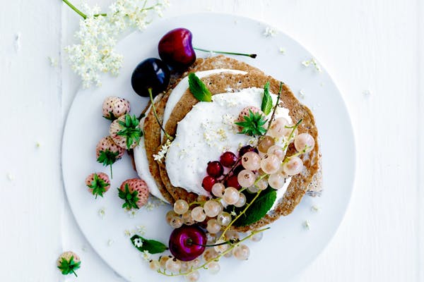 Tallerken med pandekager med hytteost, bær og skyr-creme