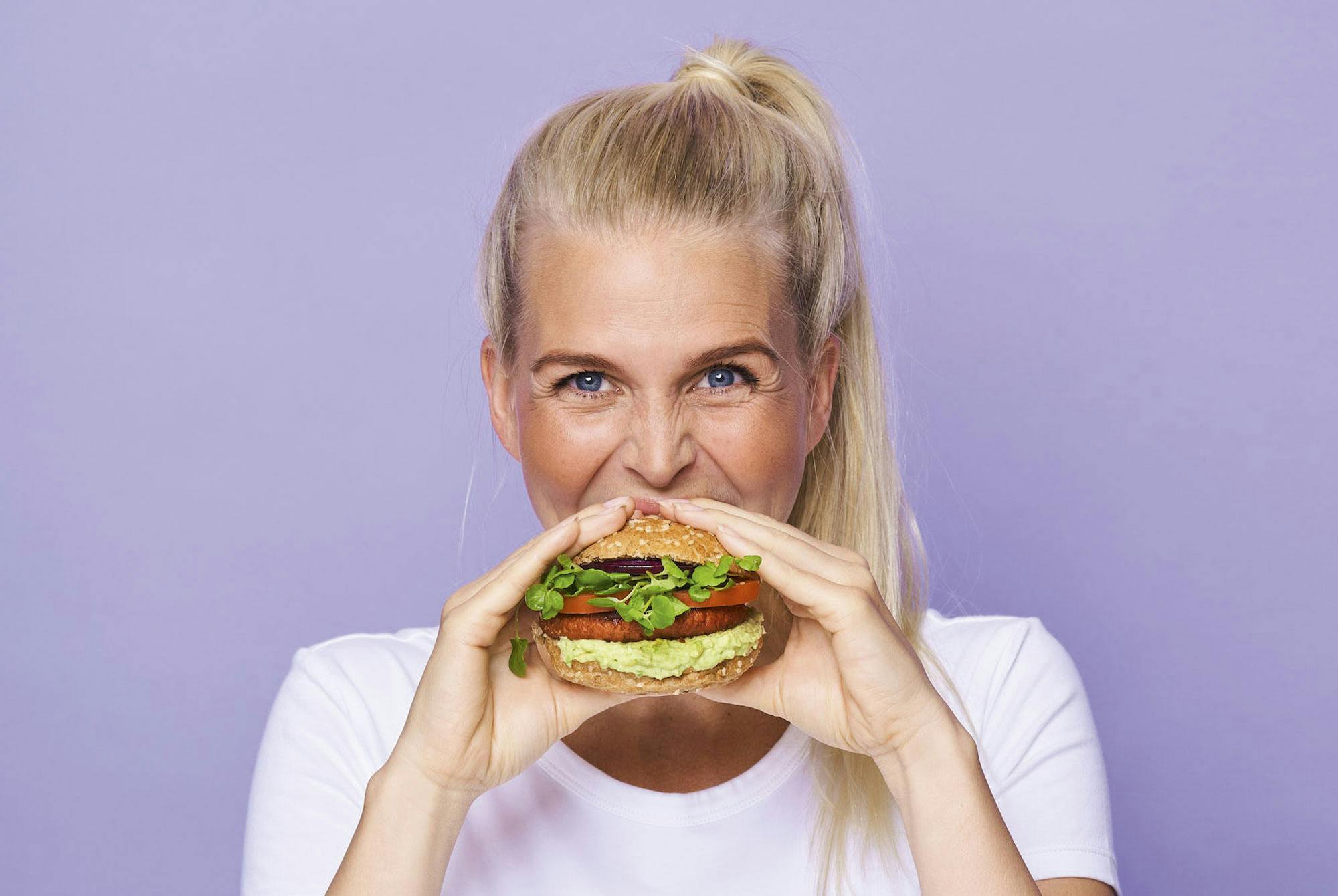 Kvinde spiser planteburger