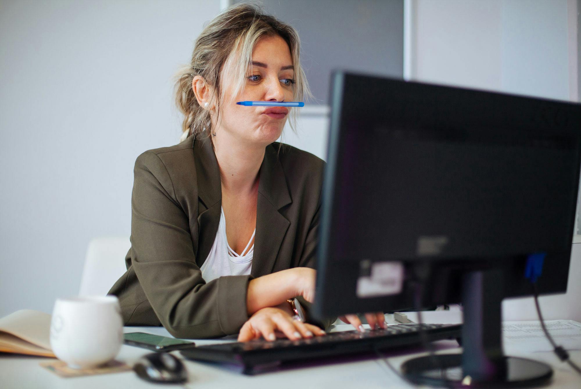 Procrastination: Kvinde sidder ukoncentreret bag sin computer