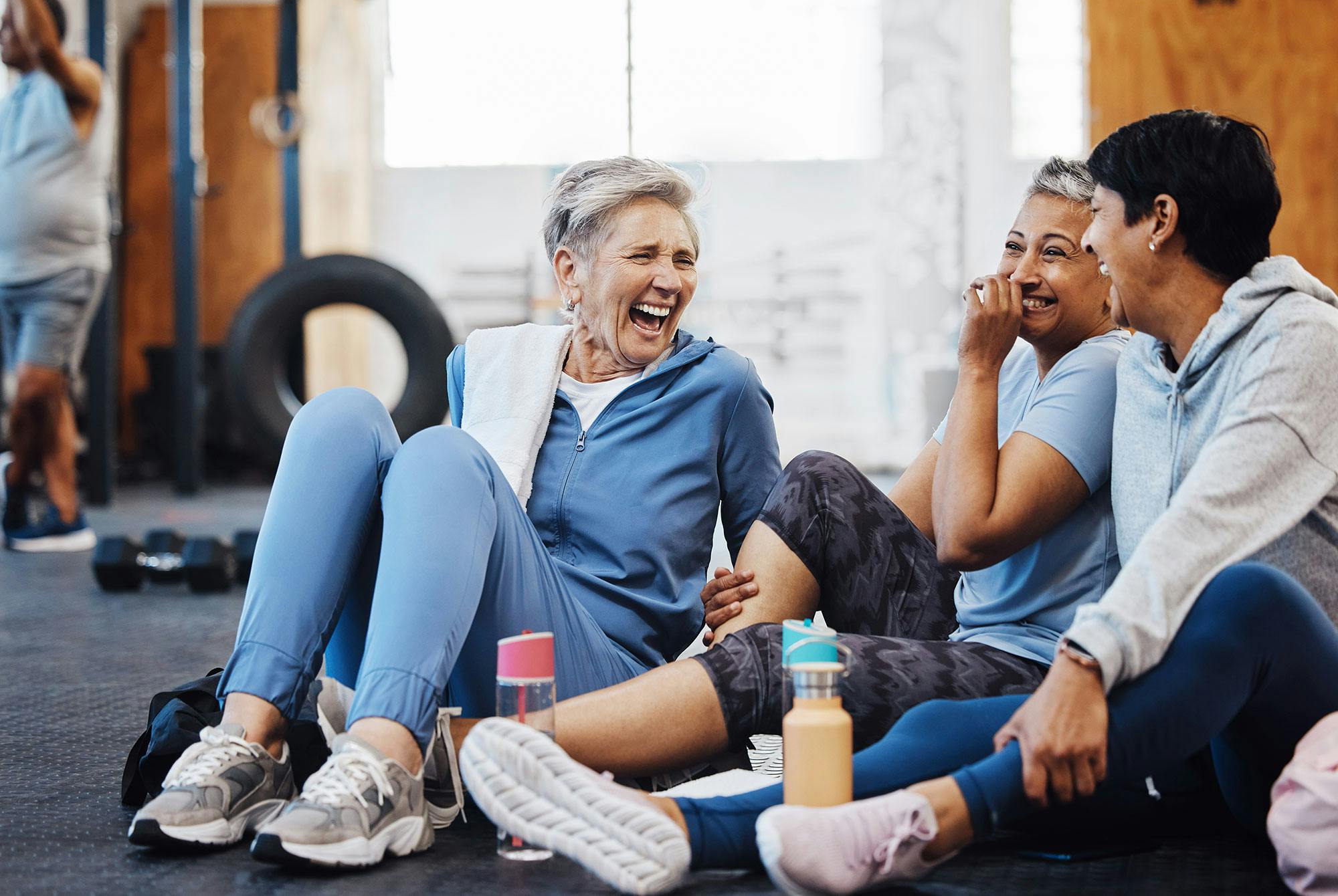 3 midaldrende kvinder træner sammen i et fitnesscenter. De har fundet en motivation.