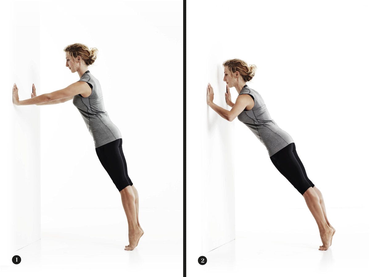 Kvinna gör armhävningar mot vägg