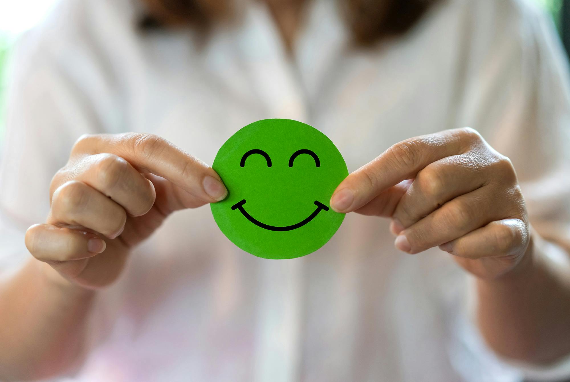 kvinna som håller en glad smiley