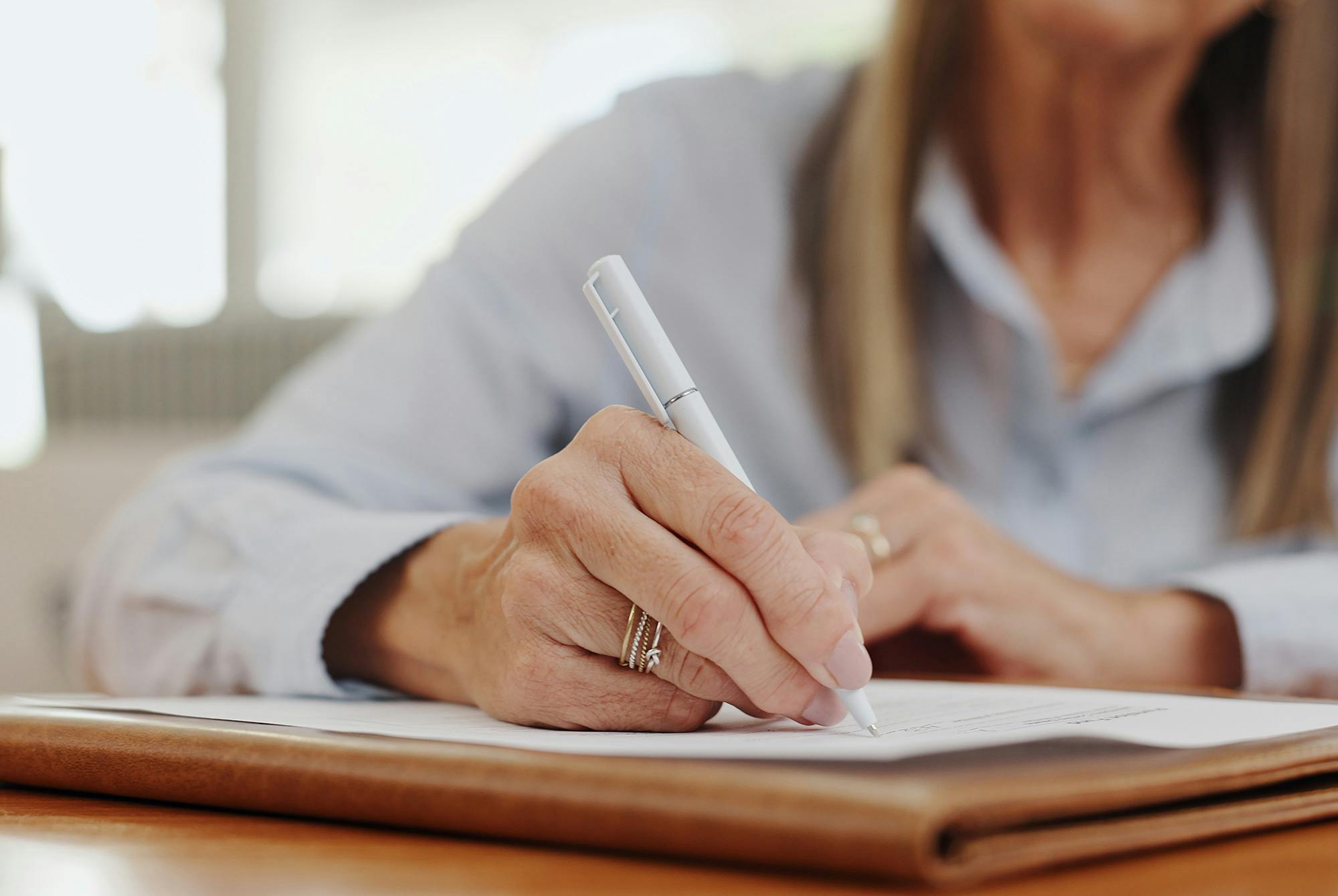 Kvinne skriver ned oppgaver for hånd