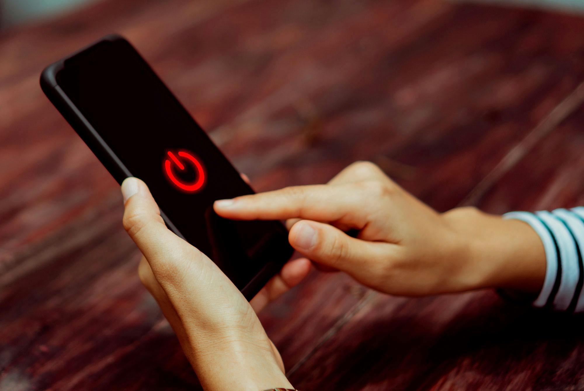 Nainen sammuttaa puhelimensa digipaaston ajaksi