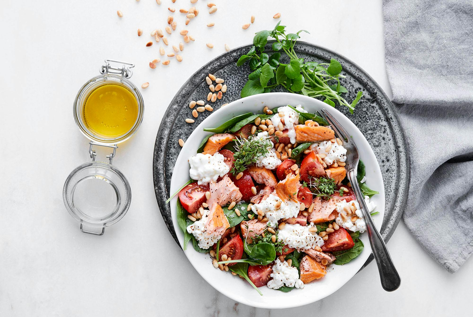 Spinatsalat med røykt laks, hytteost og pinjekerner