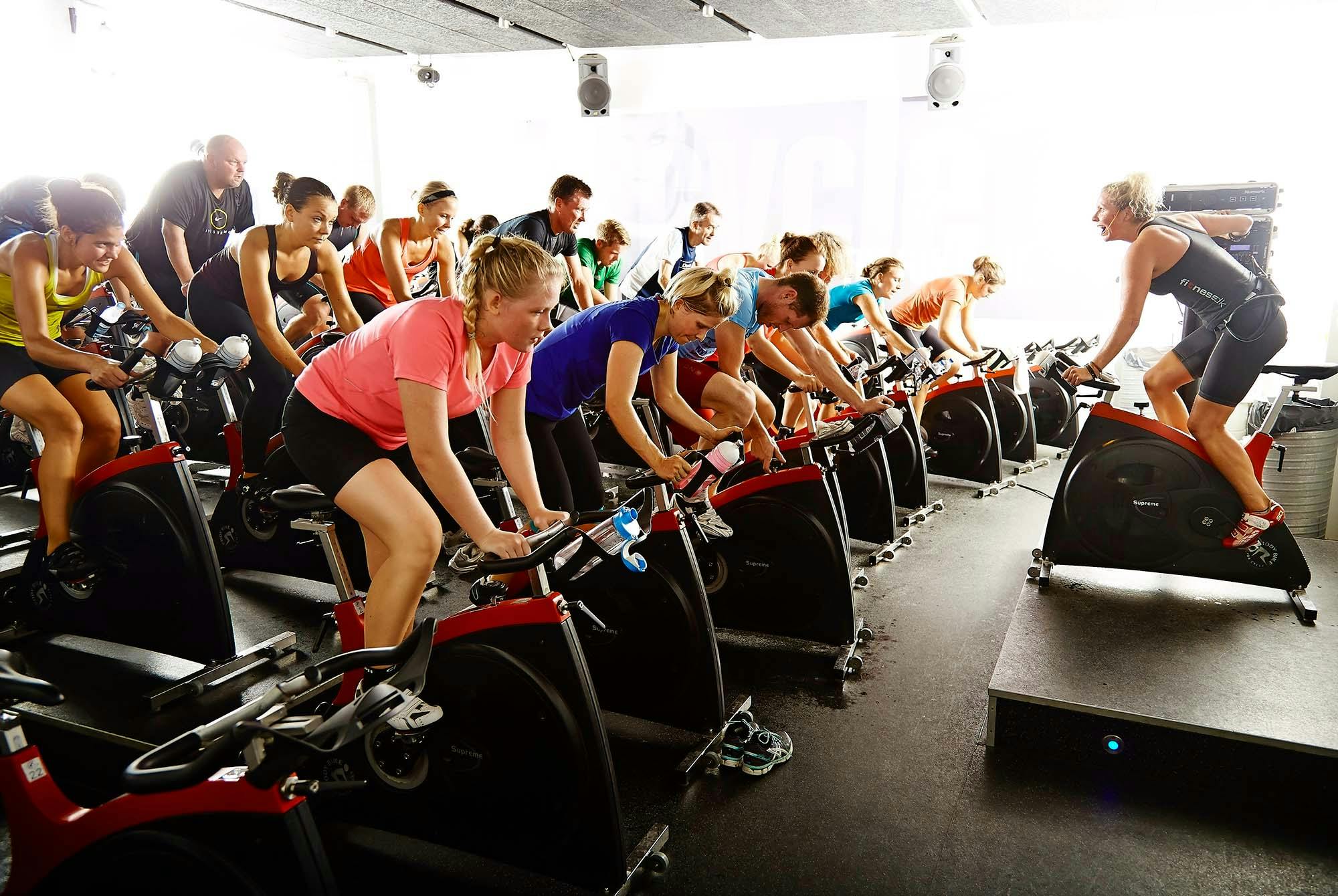 Naiset polkevat pyöriä spinningtunnilla.