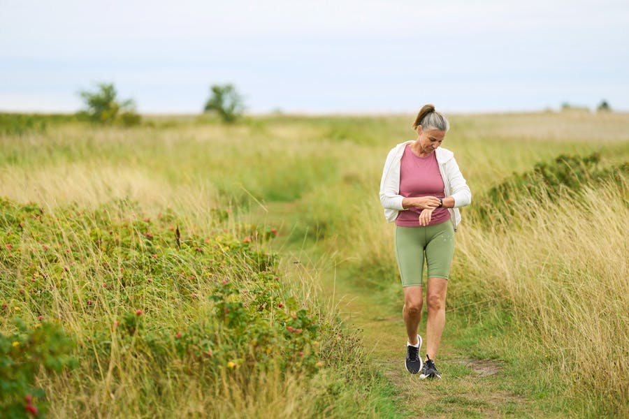 Kvinna som går i naturen på sommaren.
