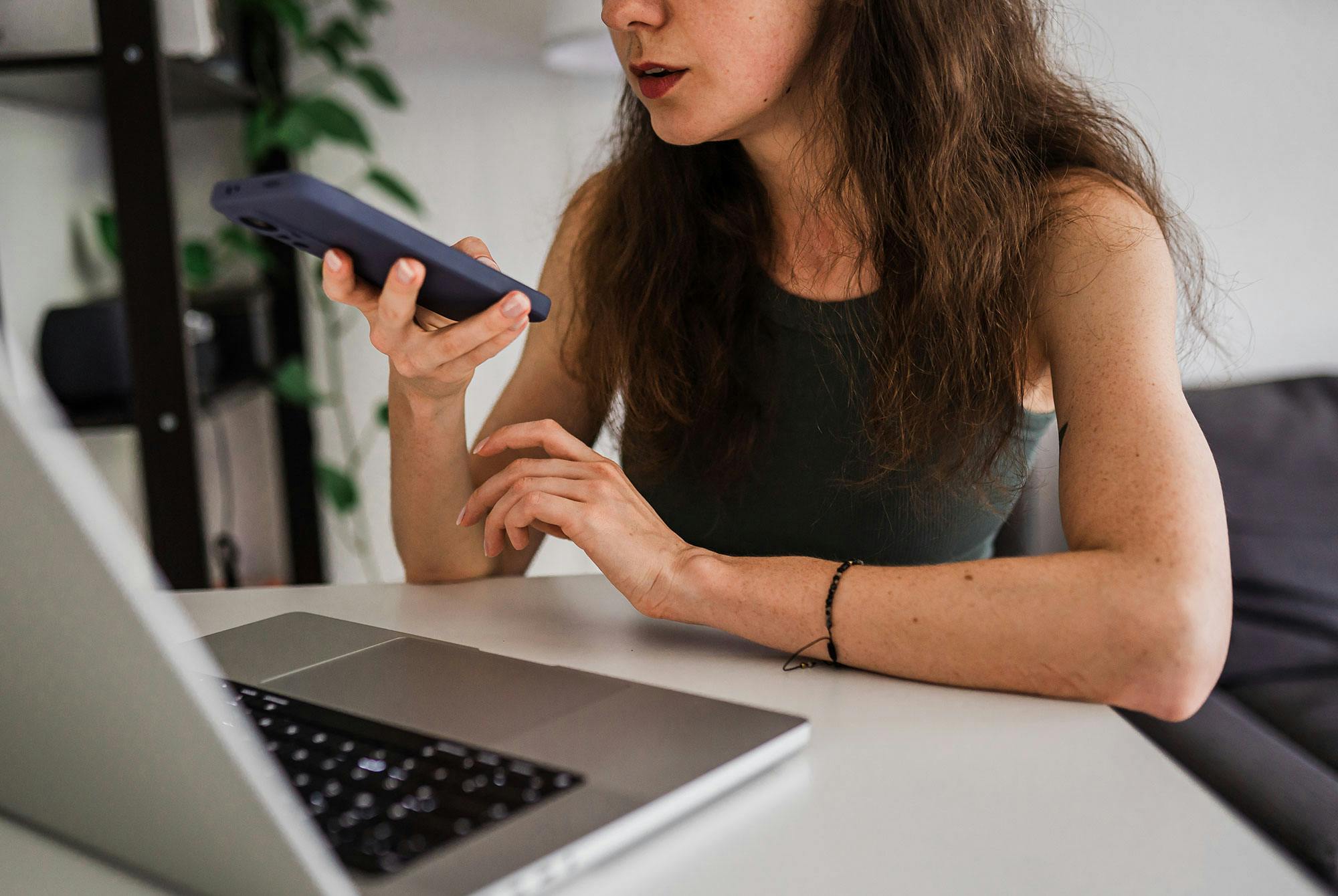 Kvinde indtaler sine personlige problemer til en chatbot på telefonen.