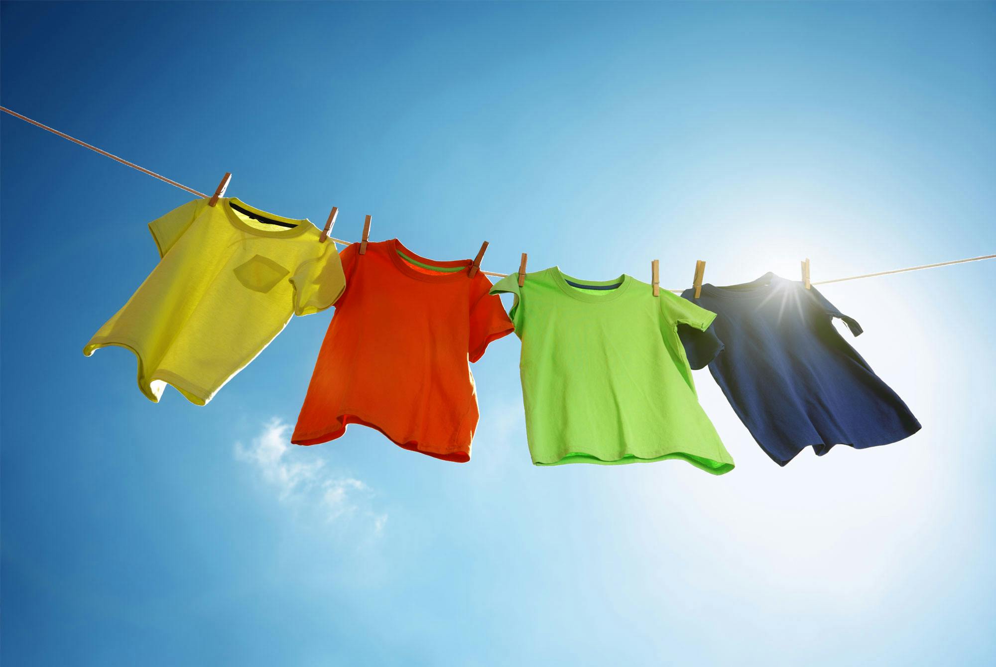 Vahvan värisiä vaatteita narulla kuivumassa