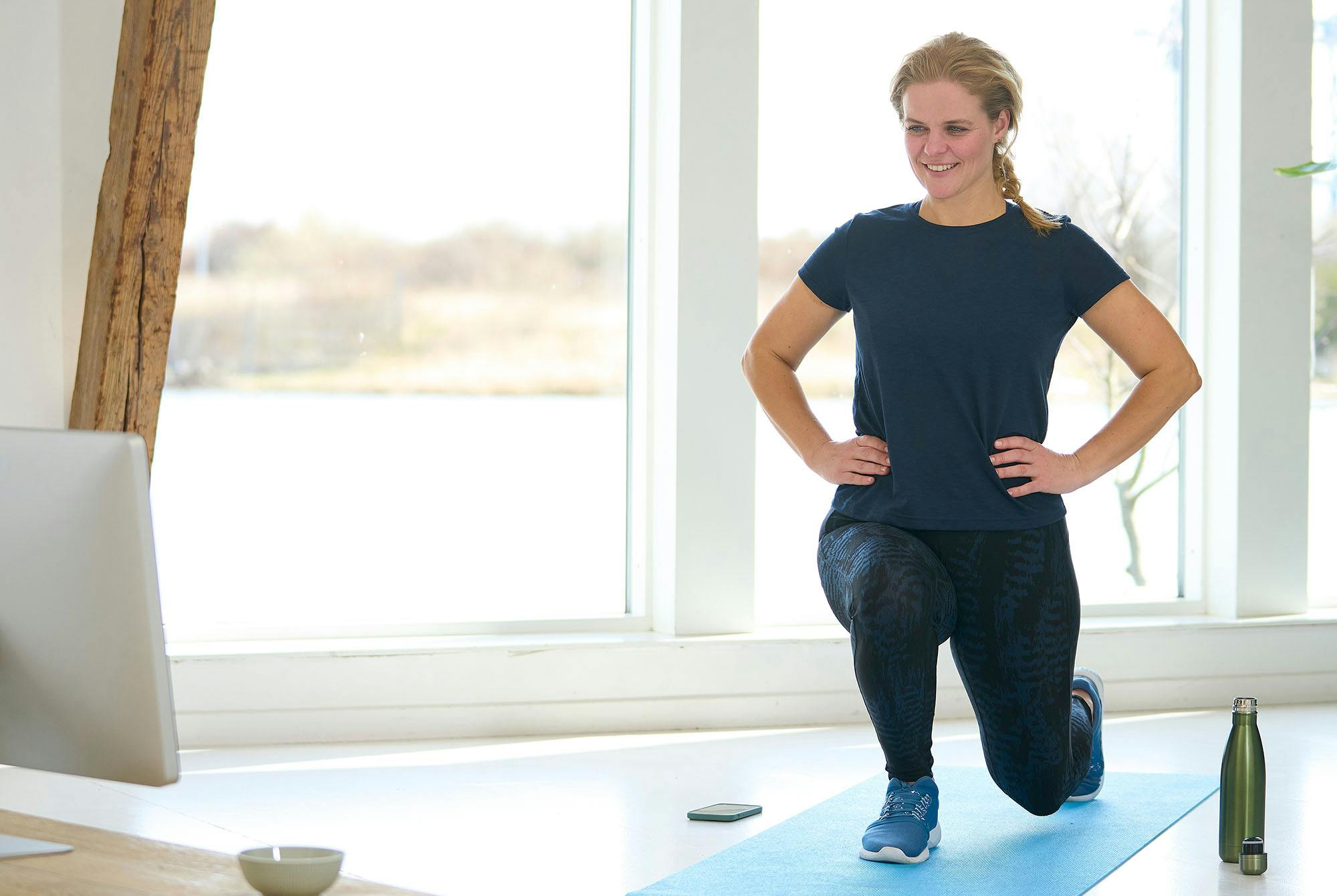 Lyshåret kvinde, der laver lunges.