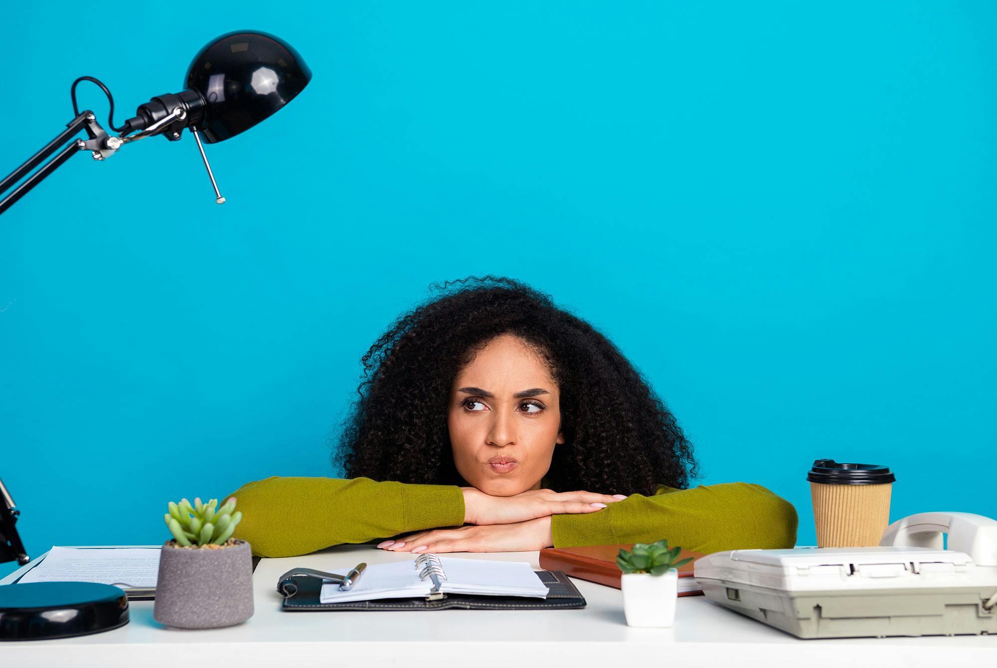 Kvinde ved skrivebord, der har problemer med procrastination.