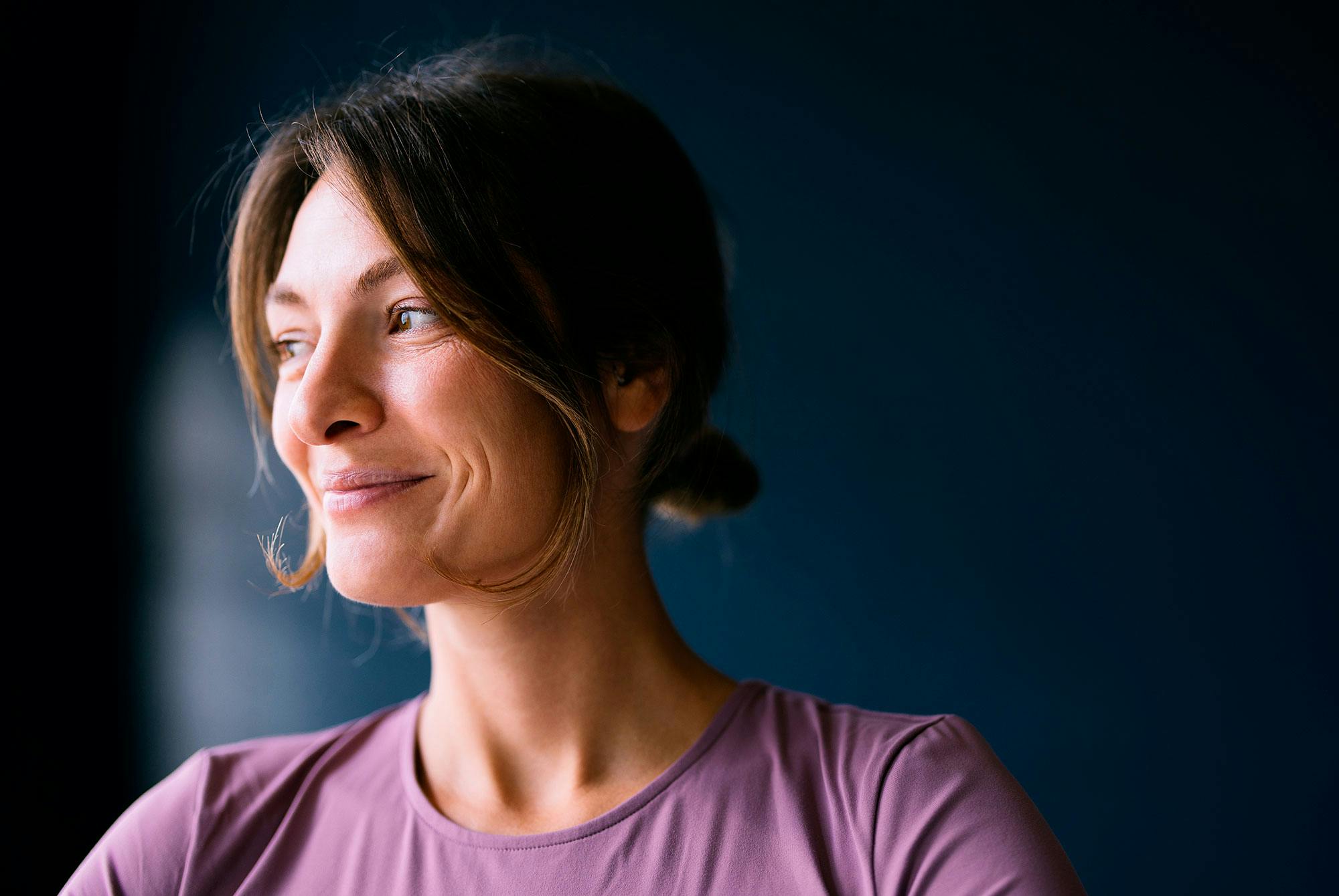 Nainen hymyilee, koska on harjoittanut shinrin-yokua