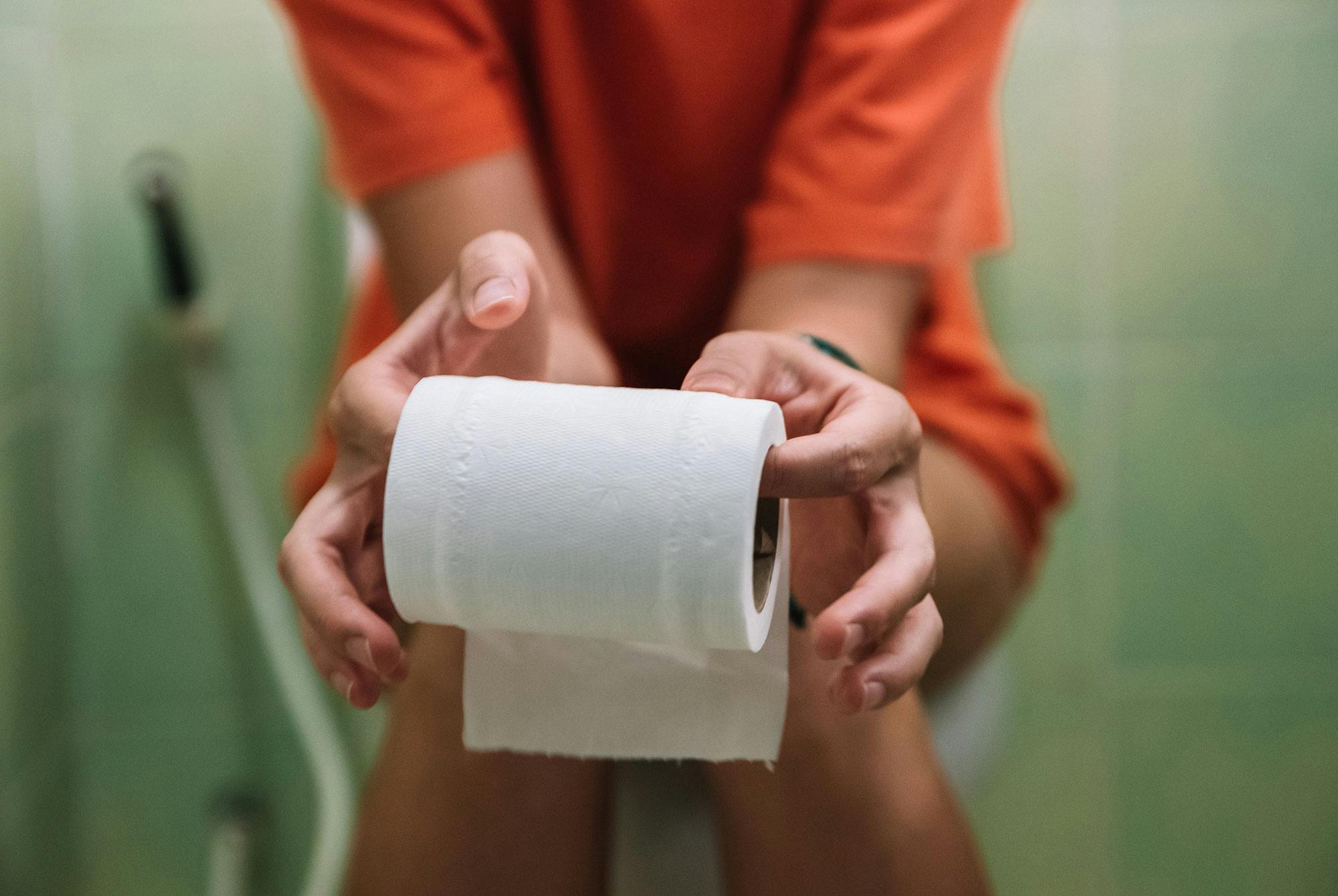 Kvinde sidder på toilet med blærebetændelse.