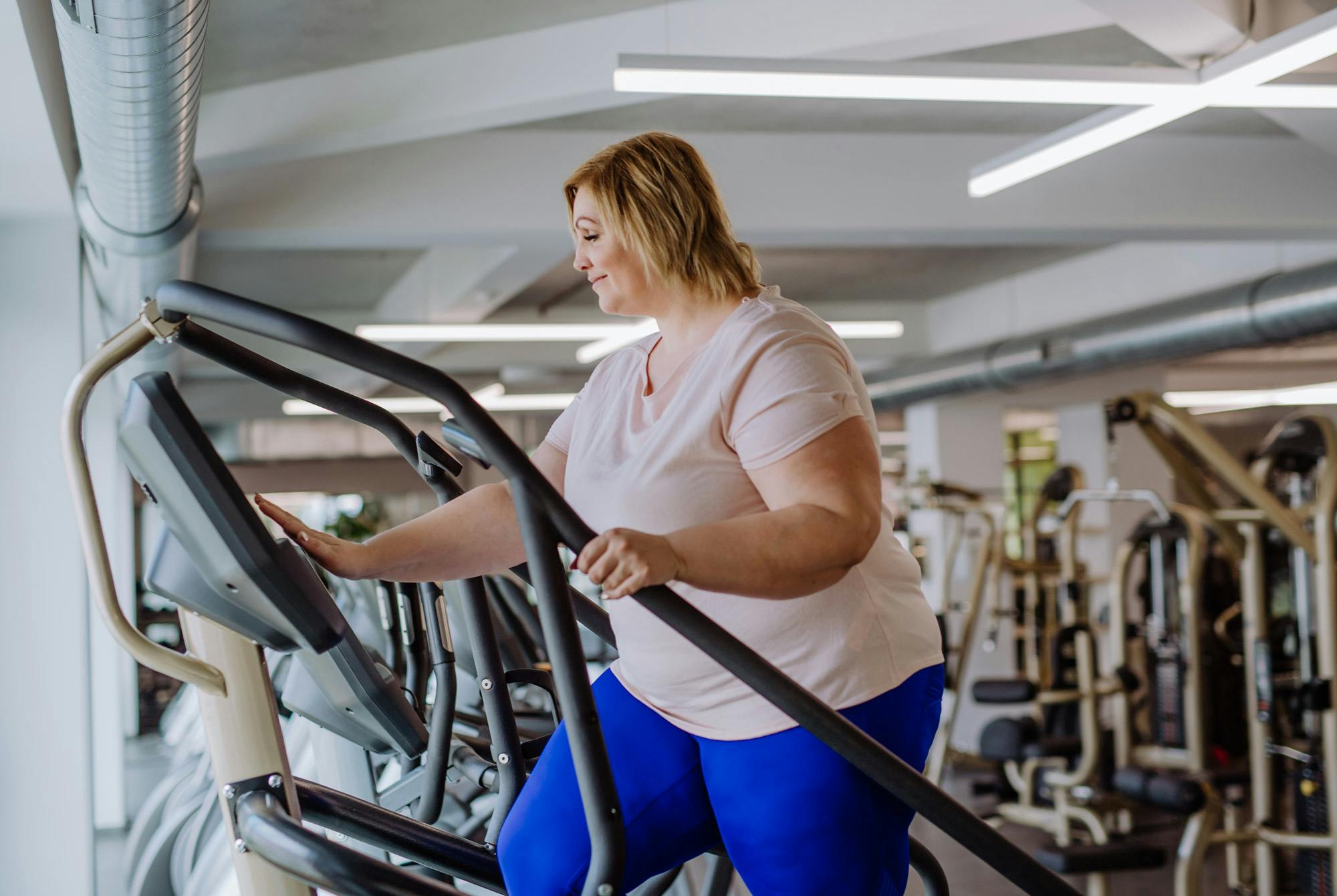 Överviktig kvinna tränar på gym