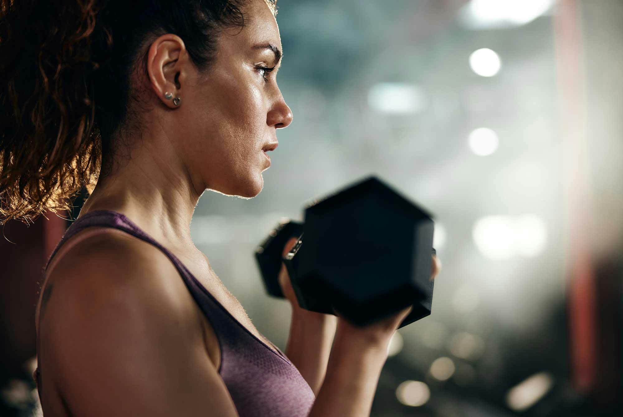 Kvinna med hantel på gym