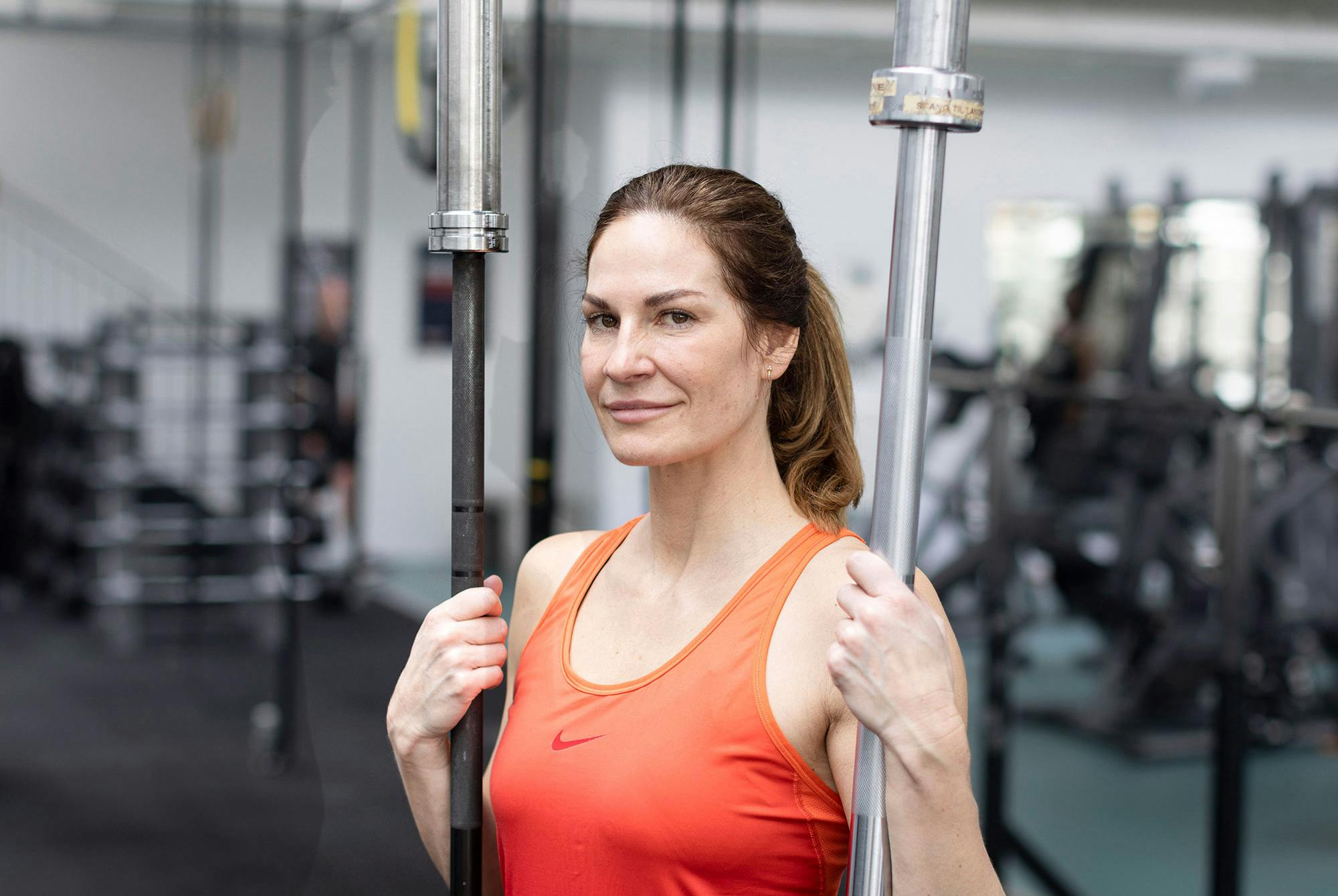 Kvinna på gym med två olika skivstänger