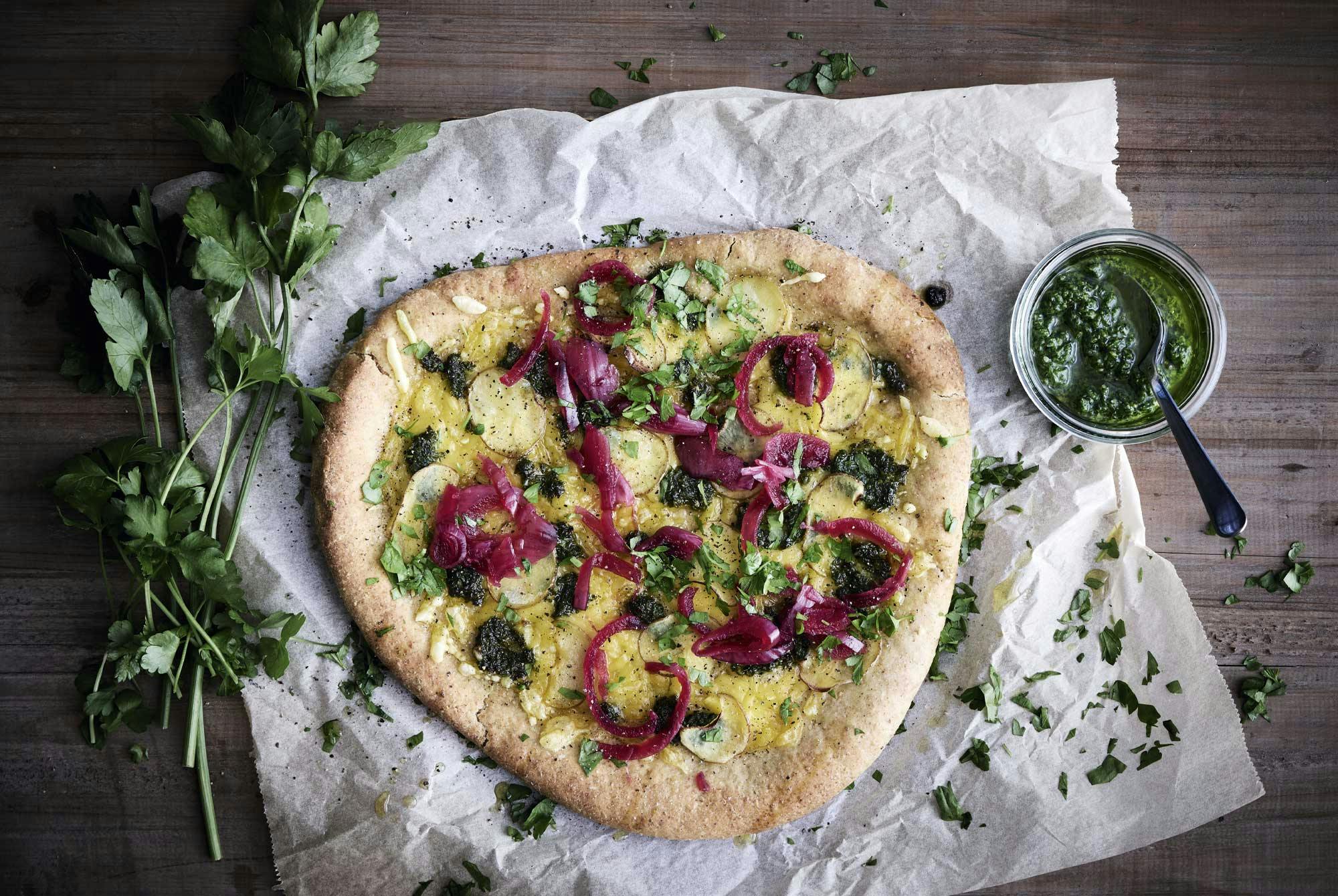 Perunoilla, pestolla ja marinoidulla punasipulilla täytetty pizza.