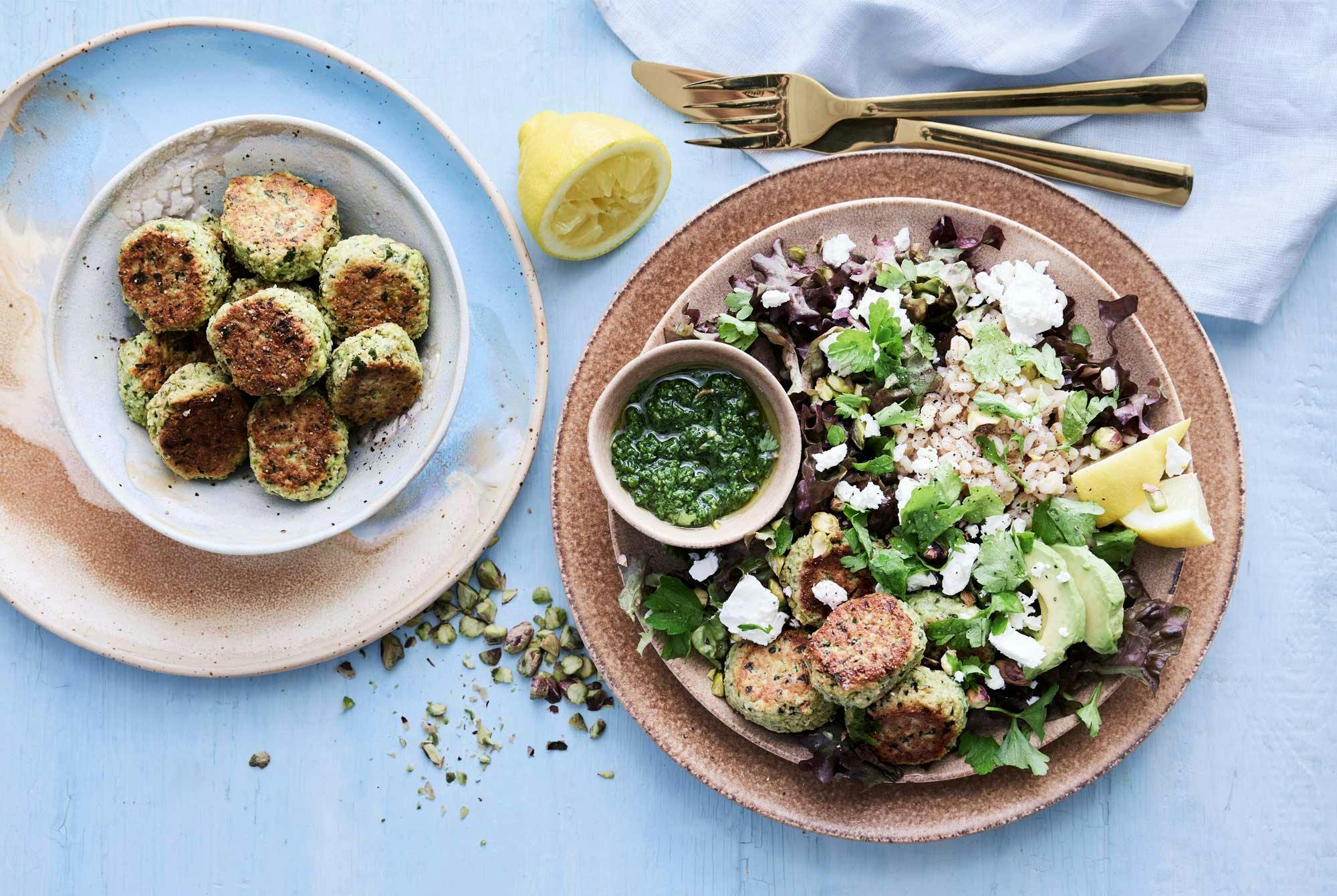 Tallerken med vegetarkaker, salat, perlebygg og persillepesto