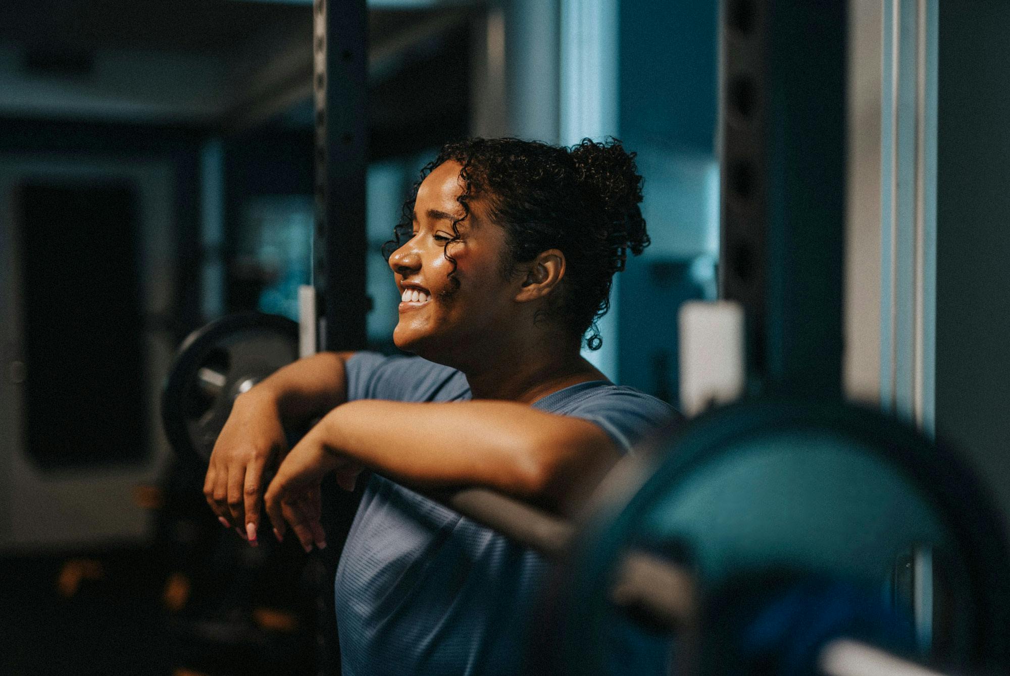 Yngre kvinna vid skivstång i fitnesscenter