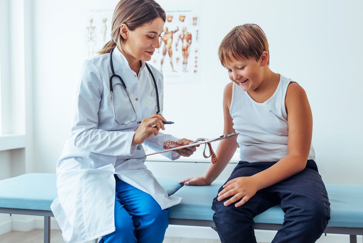 En overvektig gutt blir undersøkt og veiledet av en helsesøster.