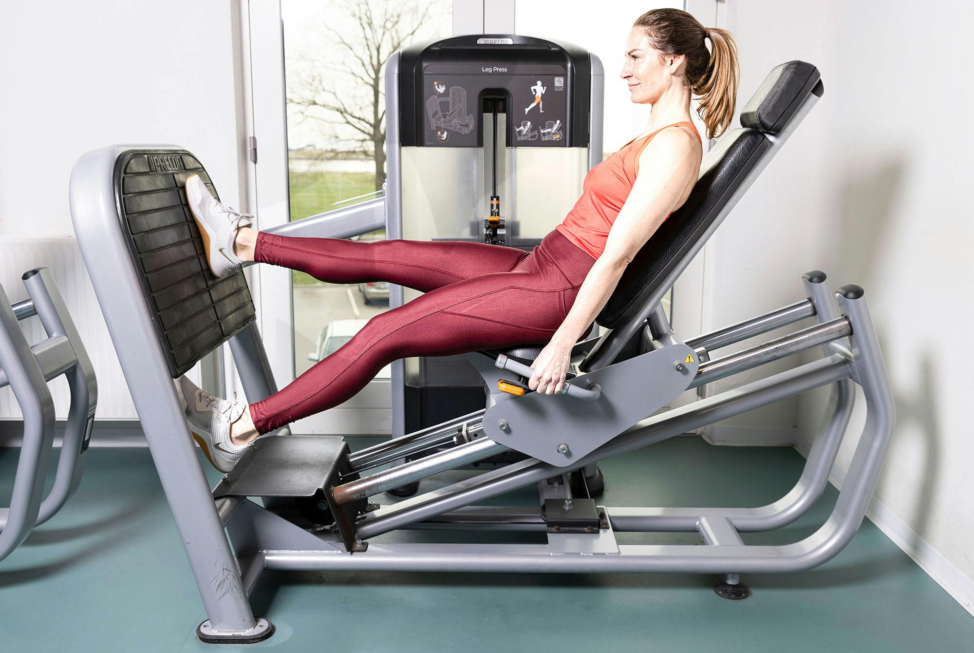 nainen tekee yhden jalan jalkaprässiä