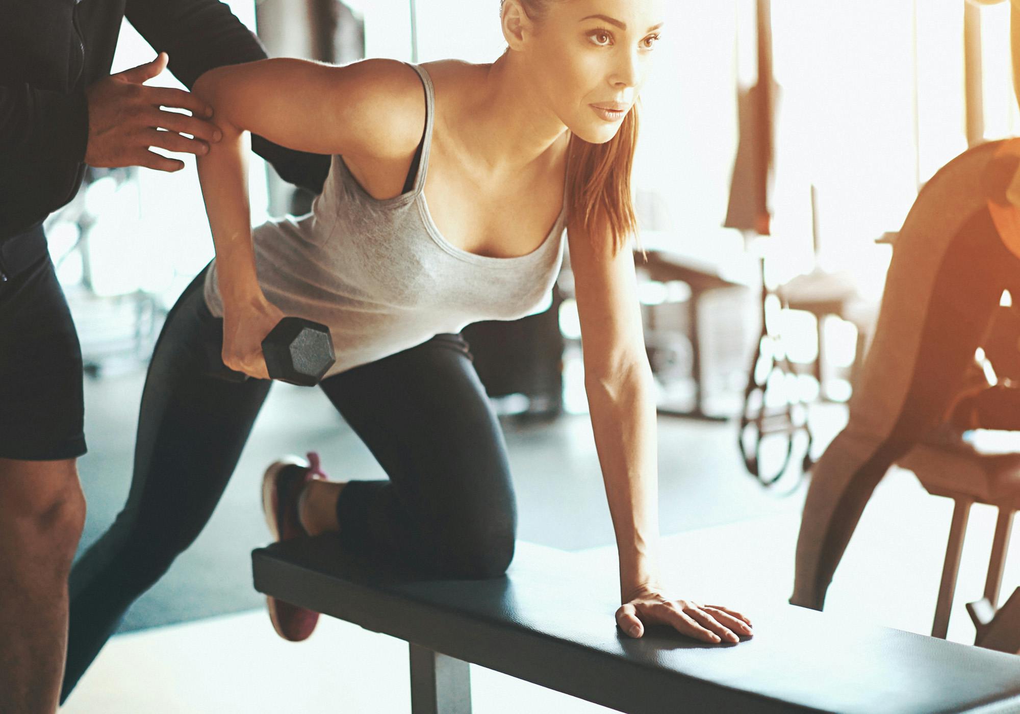 Kvinde laver bent over rows på træningsbænk