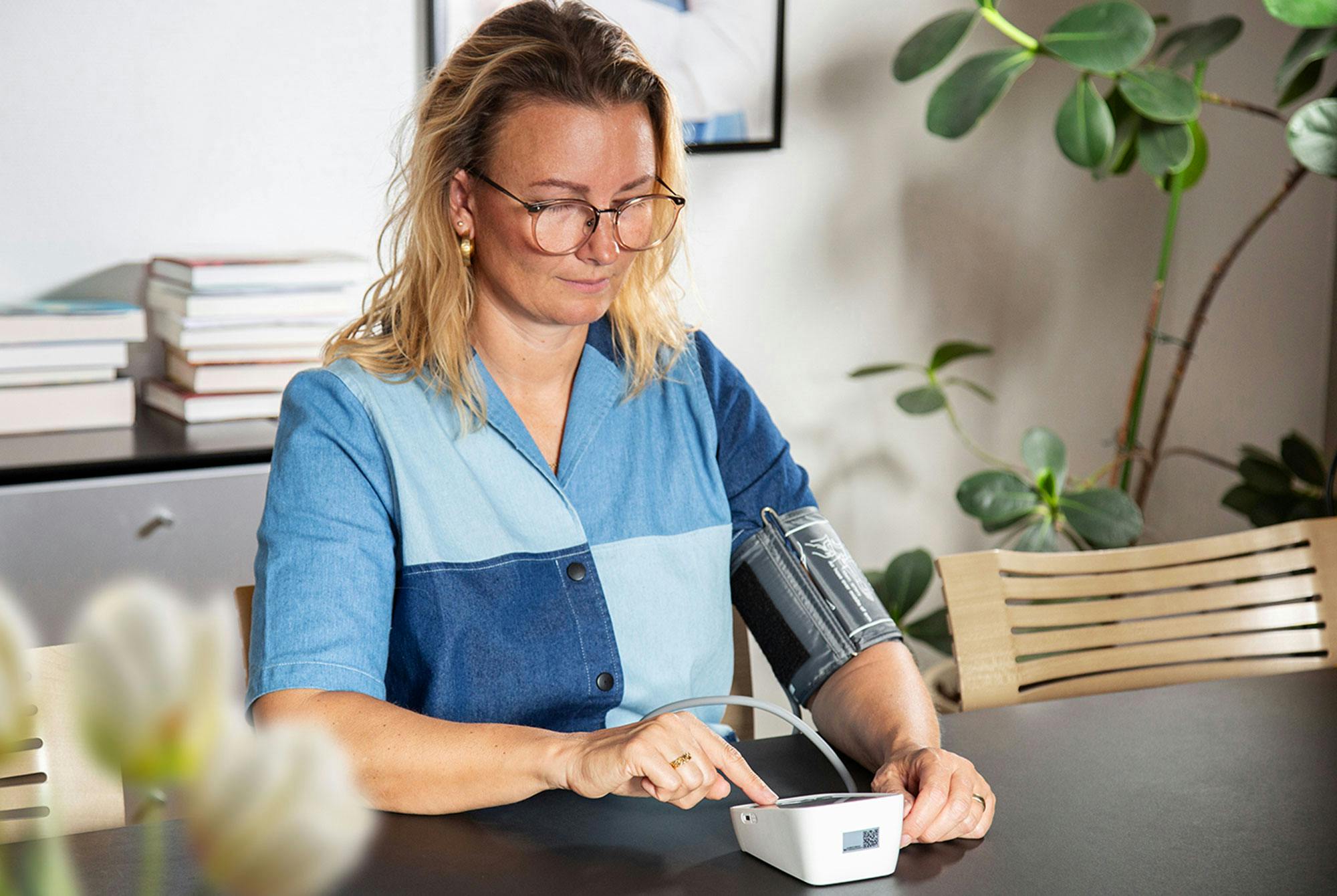 Kvinde måler blodtryk hjemme