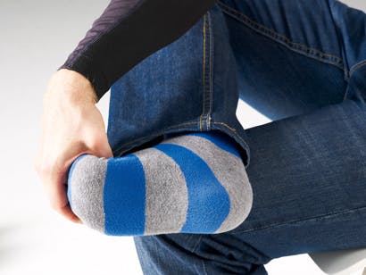 Man med hälsporre böjer foten