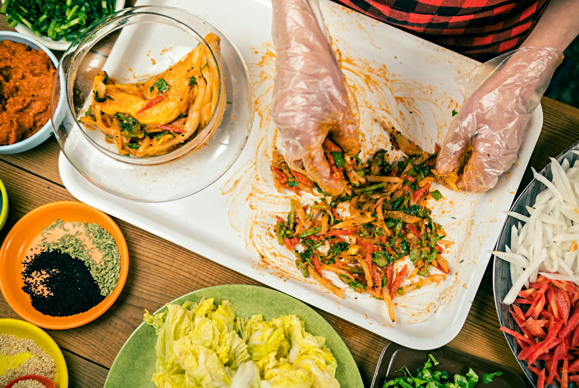 Kvinne lager kimchi med hansker på