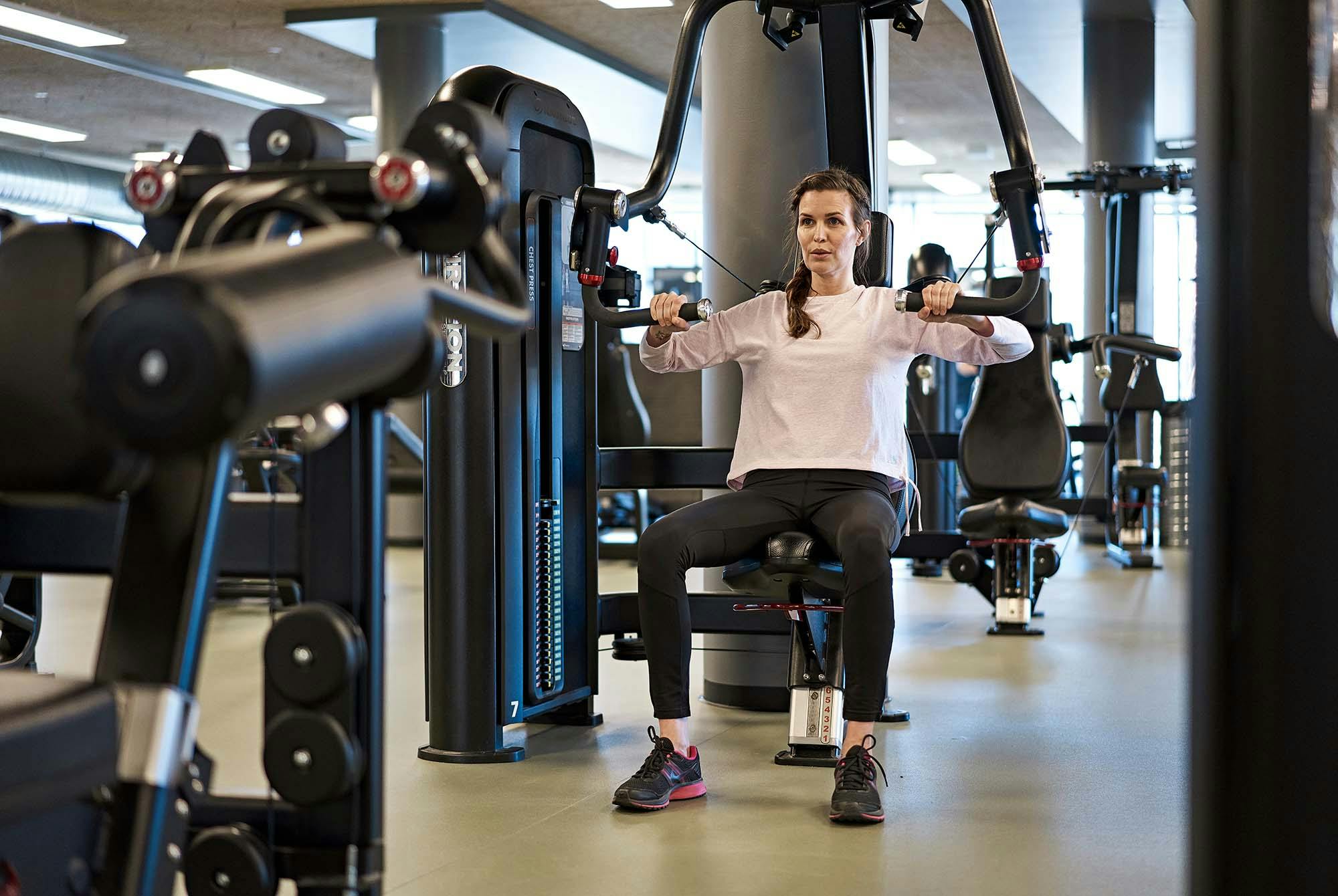 Nainen istuu rintapunnerruslaitteessa