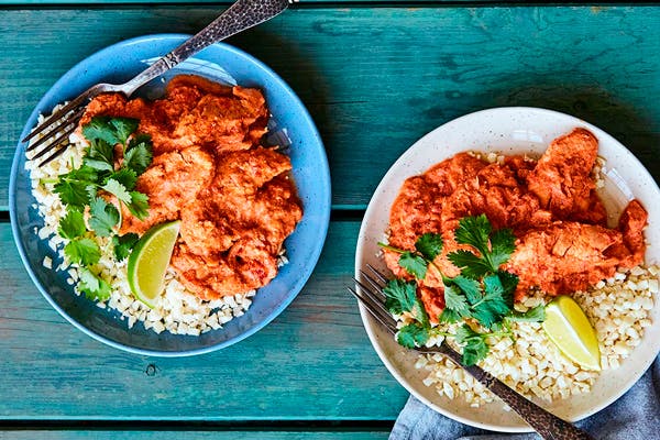 Två tallrikar med butter chicken och blomkålsris
