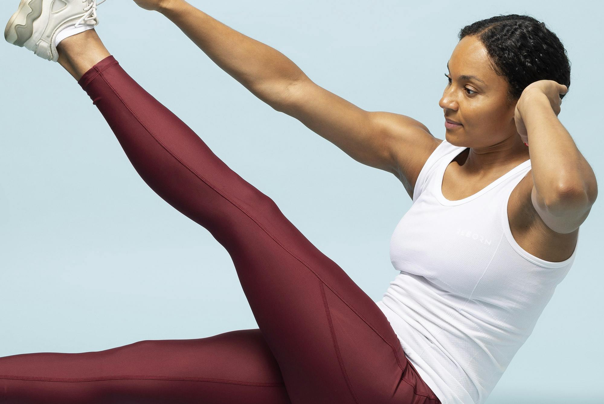 Valmentaja tekee vatsalihasharjoitetta