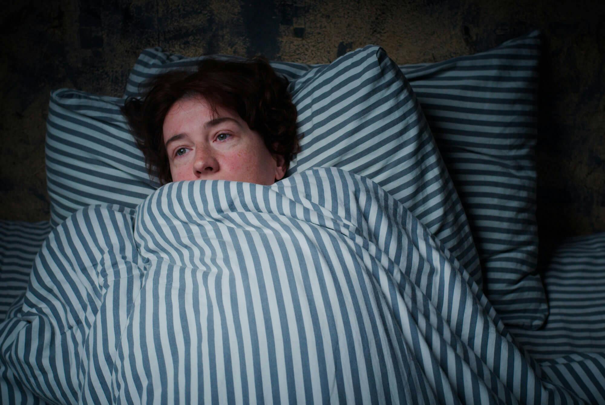 Nainen hytisee kuumeessa.