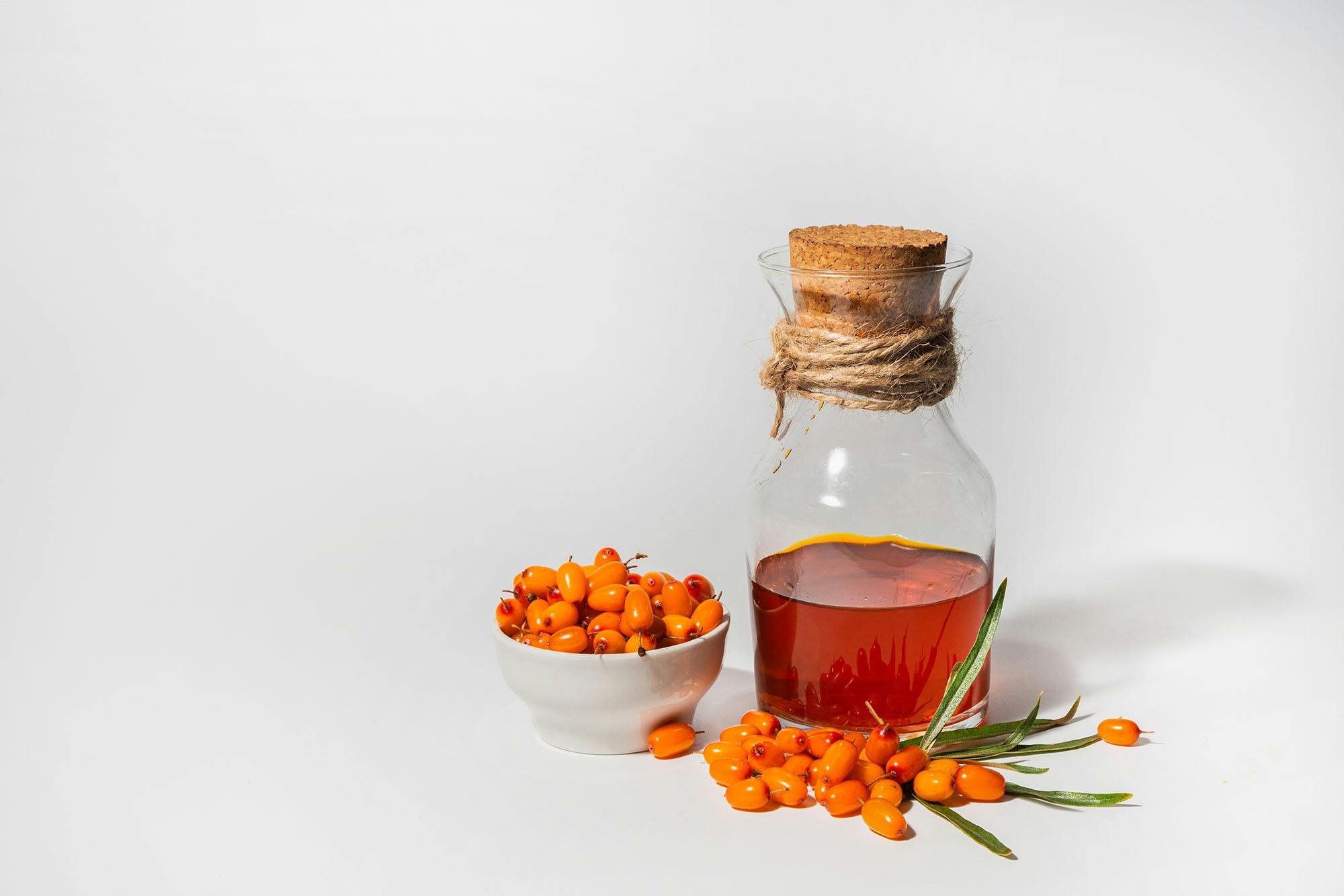 Tyrnimarjoja ja pullossa tyrnisiirappia.