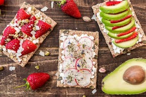 Raejuustoa leivällä avokadon ja mansikoiden kanssa.