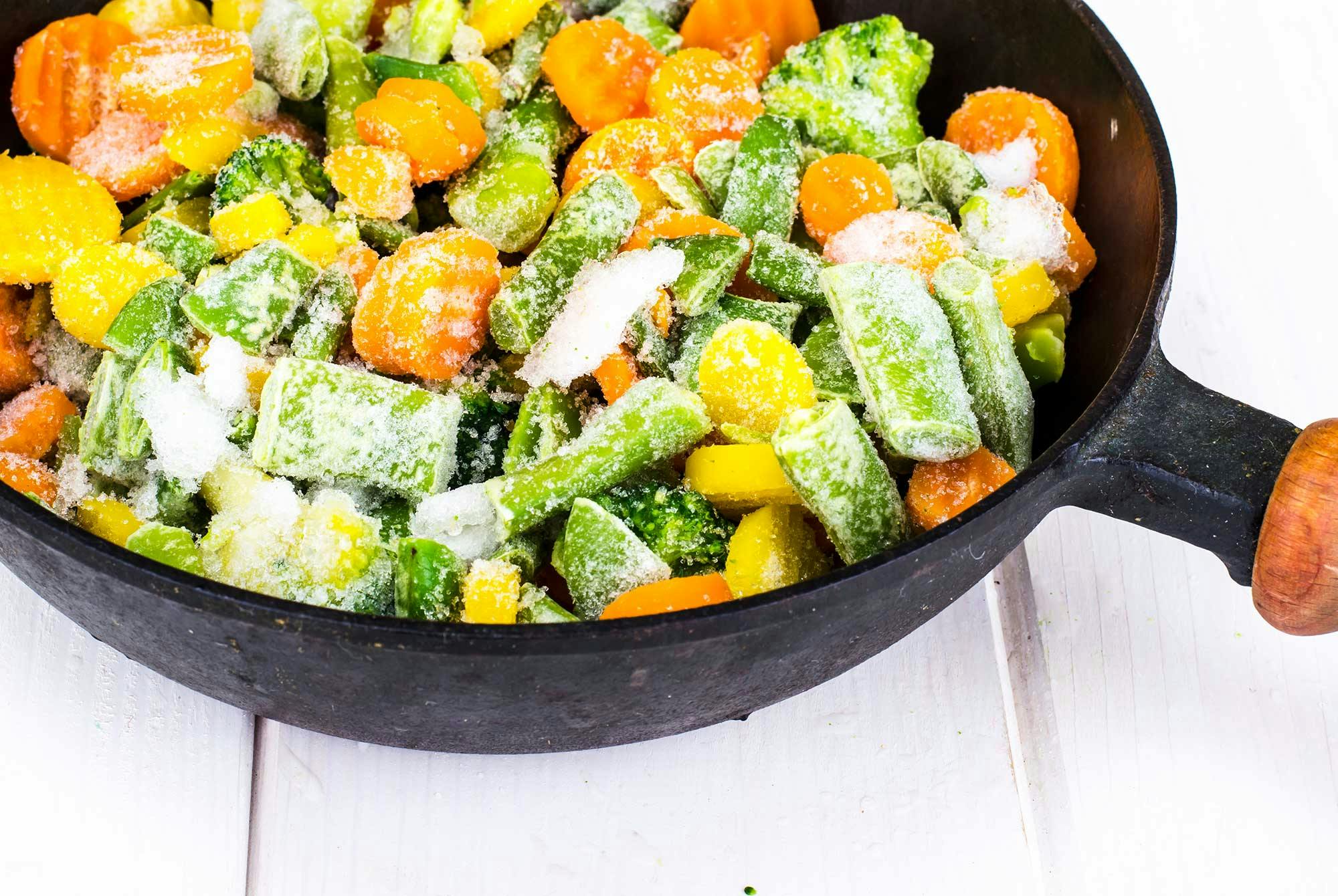 Frosne grønnsaker i en stekepanne.